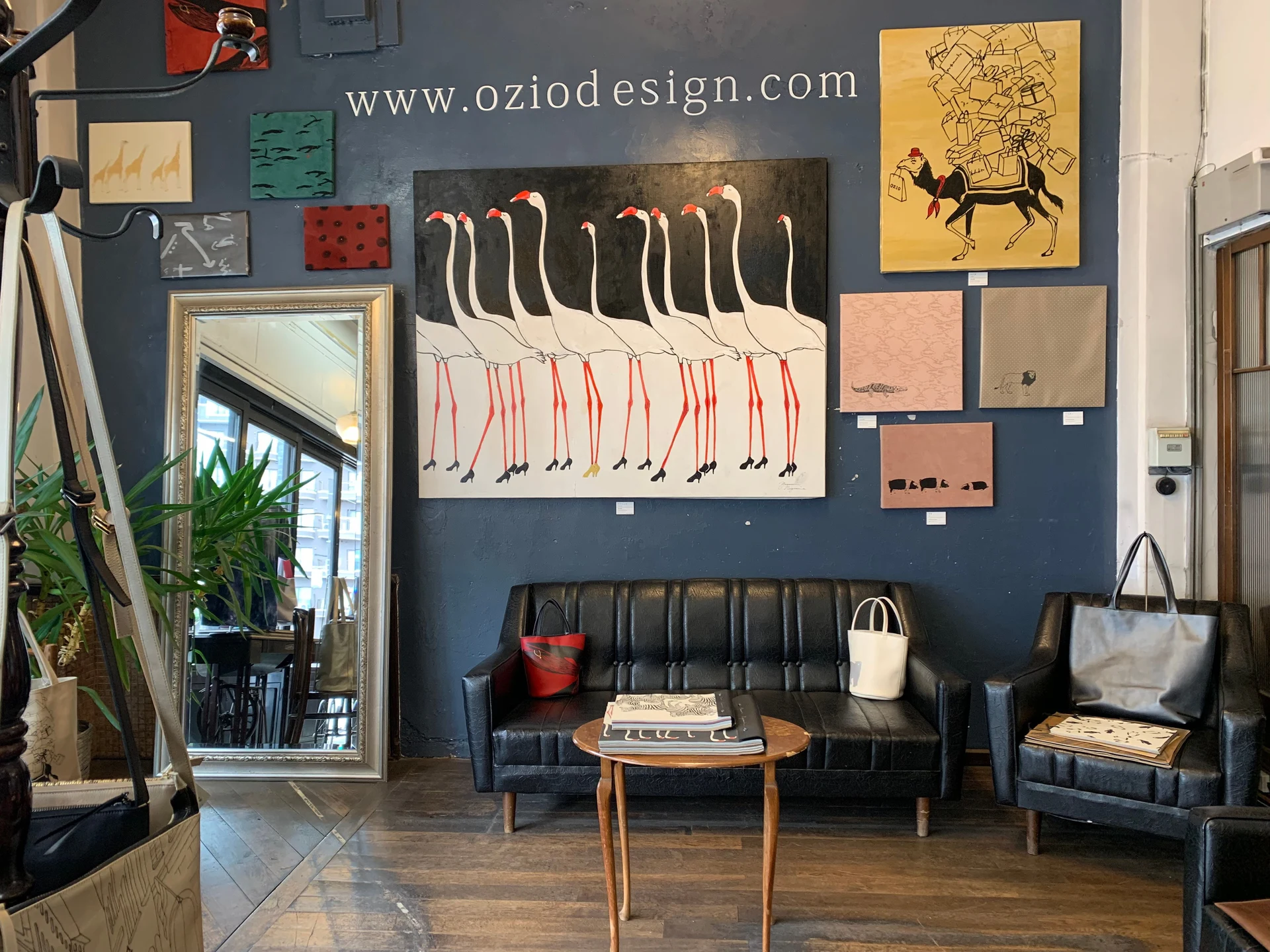 沙發旁展示紅鶴圖畫與包款的店內空間